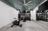 Modern and spacious home gym featuring a high-end exercise bike, well-organized weights, and a mirrored wall for enhanced workout experience.