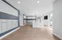 Modern apartment lobby with stylish mailboxes, elegant chandelier, and large windows offering natural light.