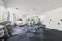 Modern fitness center with state-of-the-art equipment, including treadmills and weights, in a bright, spacious setting with city views.