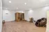 Spacious relaxation room featuring a modern sauna and luxurious massage chair, perfect for unwinding in style.