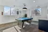 Modern game room featuring a sleek black pool table under stylish lighting, with large windows offering natural light and a vibrant view.