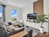 Chic living room with a cozy grey sofa, vibrant wall-mounted TV, modern dining nook, and scenic window view.