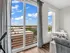 Bright and modern apartment living area with large windows showcasing a stunning city view, complemented by sleek furnishings and a cozy dining nook.