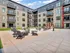 Modern apartment complex featuring spacious outdoor patio with stylish seating and fire pit, perfect for relaxation and social gatherings.