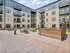Modern apartment complex courtyard featuring stylish seating, fire pit, and lush grass areas, perfect for social gatherings.