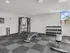 Modern fitness room with high-end equipment, weight bench, and dumbbells, offering a bright and inviting space for workouts.