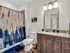 Elegant bathroom featuring modern lighting, stylish granite countertop, and a chic abstract shower curtain.
