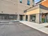 Modern apartment building exterior featuring a sleek leasing office and secure parking area.