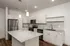 Modern kitchen with sleek stainless steel appliances, elegant granite countertops, and ambient pendant lighting, perfect for gourmet cooking.