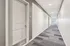 Bright and modern apartment hallway with sleek carpeting and contemporary doors, leading to a sunlit window view.