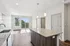 Bright and airy kitchen and living area with wood flooring, granite countertops, and pendant lighting opening to a balcony with scenic views.