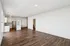 Bright and spacious open-plan apartment with elegant wooden floors, showcasing a modern kitchen with sleek stainless steel appliances and contemporary lighting.