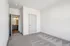 Bright and airy bedroom featuring plush carpeting and a stylish gateway to a modern bathroom.
