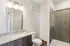 Modern bathroom with elegant granite countertops, sleek dark wood cabinetry, and a spacious glass walk-in shower.