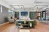Modern and inviting open-concept living room with chic decor, featuring a cozy green sofa, elegant chairs, and a stylish dining area with abundant natural light.