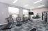 Contemporary home gym with state-of-the-art fitness equipment, large windows for natural light, and modern design.