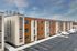 Modern apartment building with sleek brick and wood facade, ample parking, and a fresh, contemporary design.