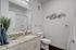 Elegant bathroom with modern fixtures, granite countertop, and artistic bicycle wall decor.