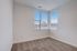 Bright, cozy room with large corner windows and plush carpeting, offering picturesque views.