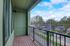 Charming apartment balcony with cozy wooden flooring and an expansive view of a tranquil neighborhood, perfect for relaxing mornings.