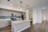 Modern kitchen with elegant granite countertops, sleek cabinetry, and a stylish tile backsplash, featuring stainless steel appliances and warm wood flooring.