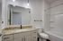 Elegant modern bathroom with granite countertops, sleek cabinetry, and stylish lighting.