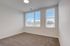 Bright and airy bedroom with plush carpeting and large windows offering a serene view.