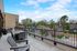 Expansive terrace with stylish outdoor seating offering delightful views of lush greenery and blossoming trees.