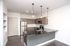 Modern kitchen with sleek stainless steel appliances, elegant pendant lighting, and a spacious black granite countertop.
