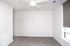 Bright and airy room with fresh, neutral tones, soft carpeting, and a modern ceiling fan for comfort.
