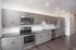 Modern kitchen with sleek gray cabinets, stainless steel appliances, and elegant tile backsplash offering a stylish culinary space.