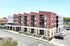 Contemporary urban apartment building with modern design and vibrant red brick facade, featuring spacious balconies for sunlight and city views.