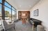 Bright and sophisticated living room with floor-to-ceiling windows, modern furniture, and built-in shelving, offering a stylish and cozy atmosphere.