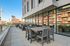 Spacious urban balcony with stylish outdoor seating, offering a chic cityscape view and sleek modern architecture.
