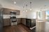 Modern apartment kitchen with sleek stainless steel appliances, elegant cabinetry, and an open layout with abundant natural light.