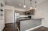 Modern kitchen with stainless steel appliances, sleek dark countertops, and stylish pendant lighting.