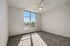 Bright and airy bedroom with plush carpeting and a large window offering scenic views, perfect for relaxation and comfort.