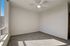 Bright, airy bedroom with plush carpet, large windows, and a ceiling fan, perfect for a cozy and inviting atmosphere.