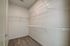 Spacious walk-in closet with organized wire shelving and plush carpet flooring, perfect for ample storage.