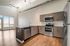 Modern open-plan kitchen featuring sleek stainless steel appliances, elegant cabinetry, and expansive windows for natural light.