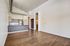Modern open-concept apartment featuring sleek hardwood floors, a stylish kitchen with stainless steel appliances, and elegant pendant lighting.