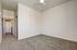 Bright, airy room with soft carpet and modern ceiling fan, perfect for cozy relaxation or an office space.