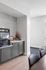 Modern kitchenette corner with sleek gray cabinetry, built-in beverage fridge, and stylish subway tile backsplash.