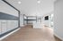 Modern apartment lobby featuring sleek mailboxes, elegant pendant lighting, and bright, airy windows with garden views.