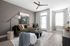 Modern living room featuring a stylish olive-green sofa, chic decor, and natural light from large windows, perfect for relaxation.