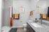 Contemporary bathroom featuring sleek granite countertops, stylish artwork, and vibrant shower curtain for a modern touch.