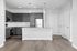 Modern kitchen with sleek dark cabinets, stainless steel appliances, and elegant pendant lighting over a spacious island.
