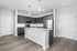 Modern kitchen with sleek gray cabinetry, stainless steel appliances, and a stylish central island with granite countertop.
