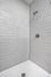 Contemporary shower area featuring sleek white subway tile walls and modern fixtures, perfect for a refreshing start to your day.