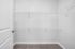 Spacious walk-in closet with modern wire shelving and plush carpet flooring, perfect for maximizing storage in a stylish apartment.